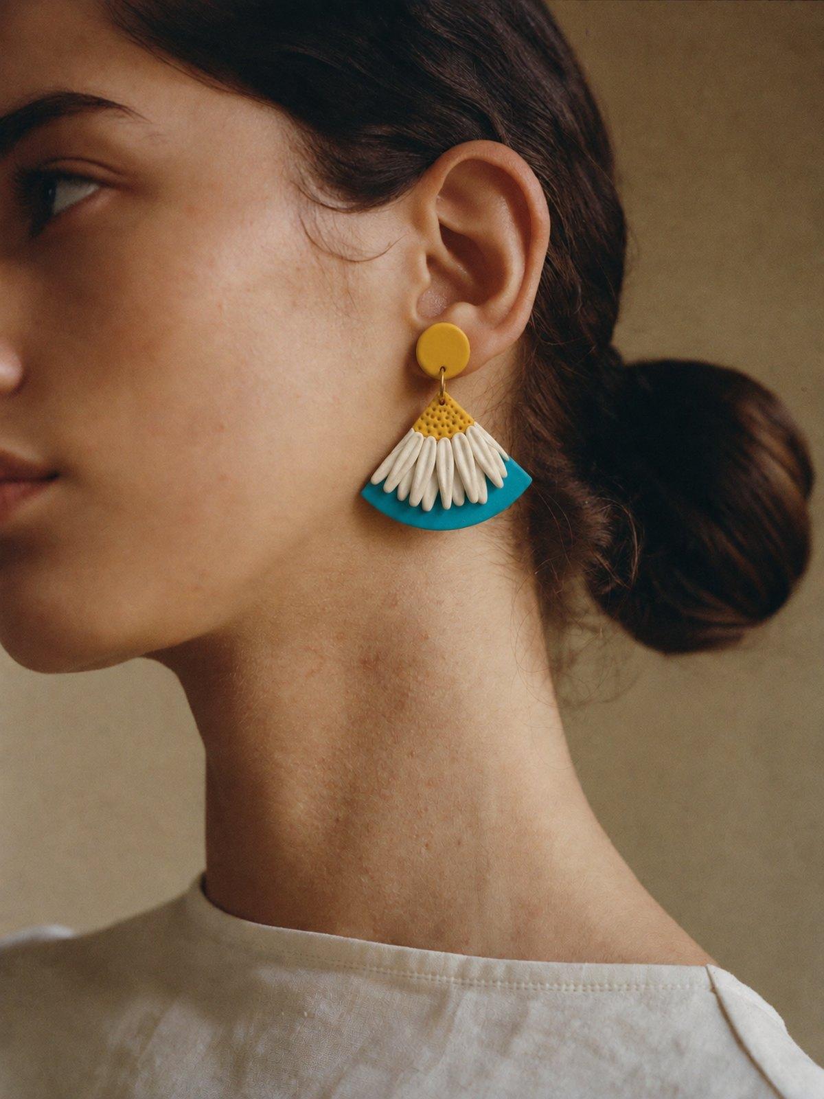 Modelo de perfil con los aros Girasoles sobre azul